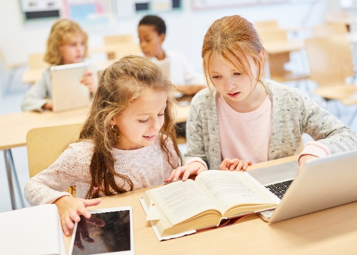 Mädchen in Grundschule lernen am Laptop Computer