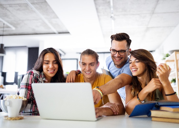 Multiracial young people enjoying group study at table.