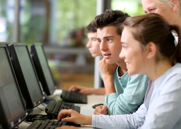Students in class working on desktop computer