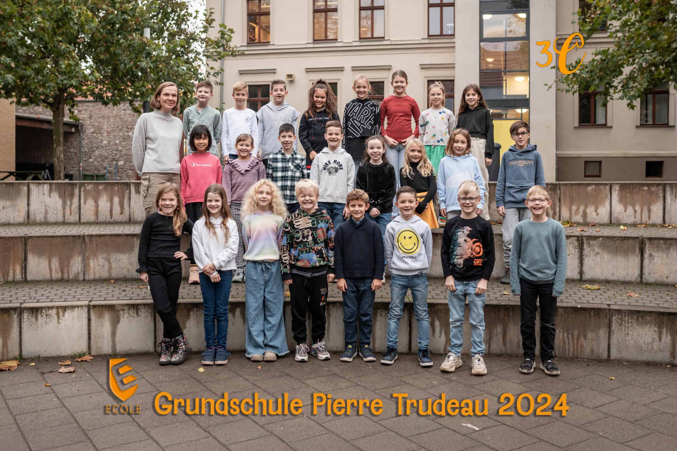 Kindergruppe lächelt auf Schulhof; bunte Kleidung; Herbstfarben; Kinderlachen.