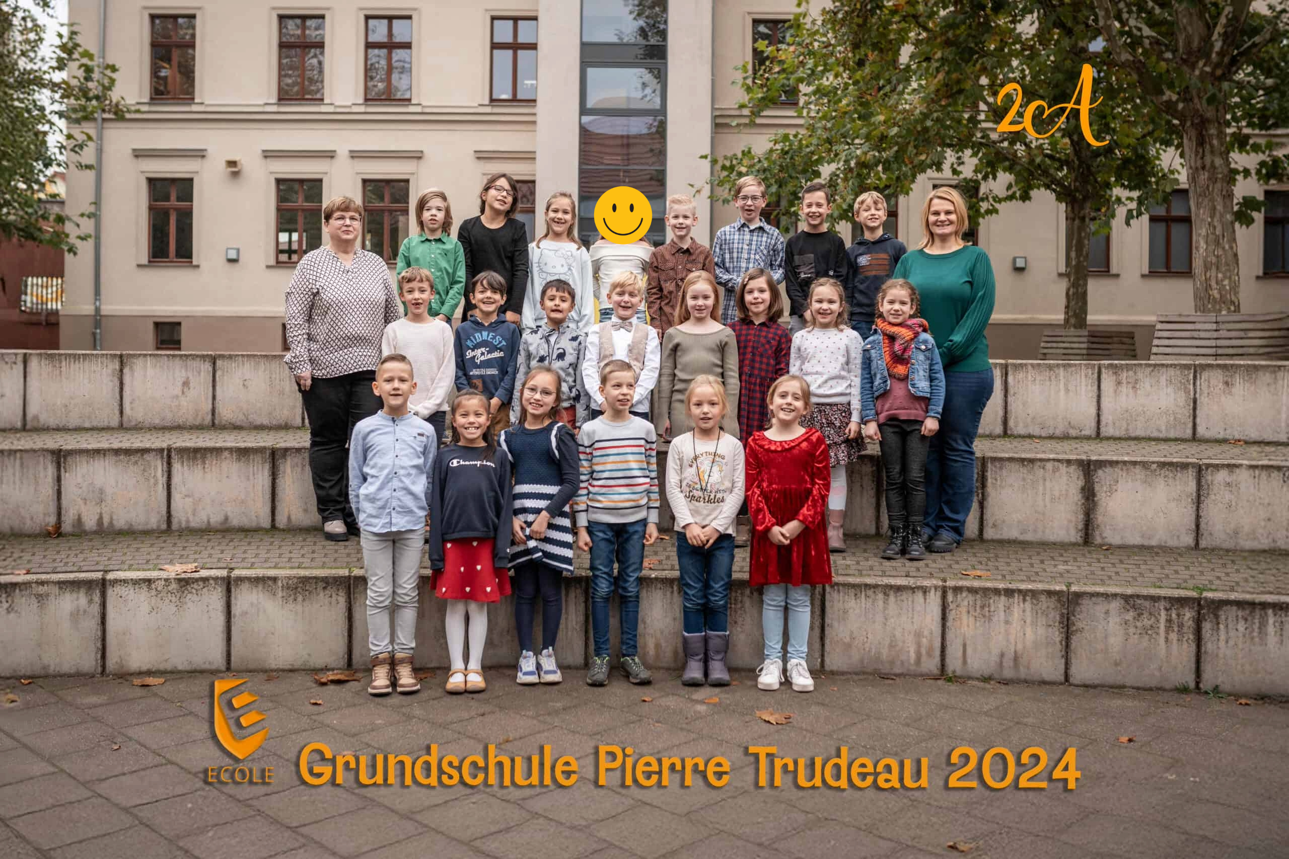 Eine Gruppe von Erwachsenen und Kindern, einige lächelnd, vor einer Schule.