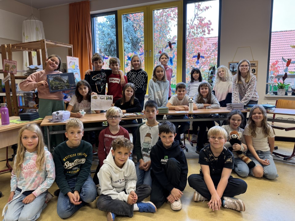 Eine fröhliche Kindergruppe sitzt und steht im bunten Klassenzimmer mit hellen Fenstern