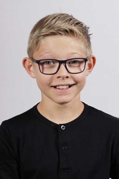 Laechelnder blonder Junge mit Brille und schwarzem Shirt