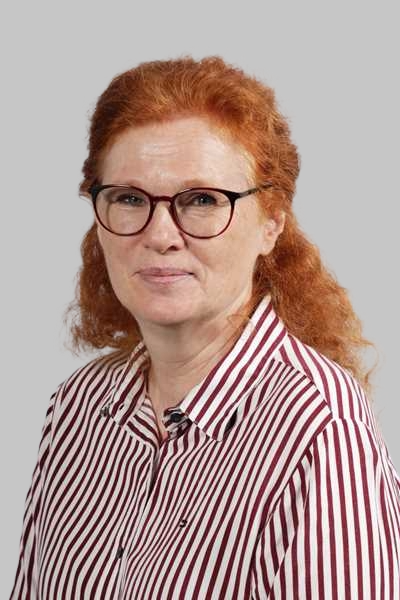 Frau mit roten Haaren und Brille traegt eine rot weiss gestreifte Bluse