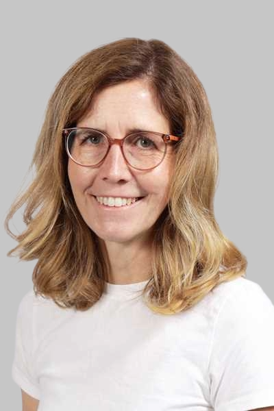 Laechelnde Frau mit Brille und blondem Haar in weissem Shirt