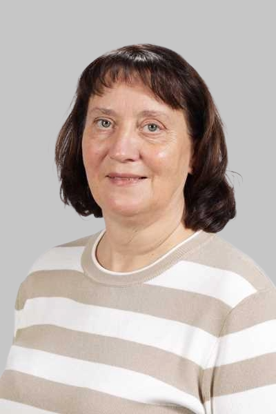 Laechelnde Frau mit braunem Haar traegt einen beige weiss gestreiften Pullover