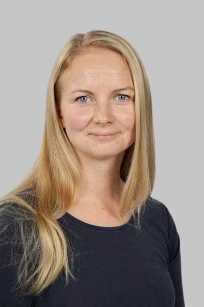 Laechelnde blonde Frau mit blauen Augen in dunklem Oberteil